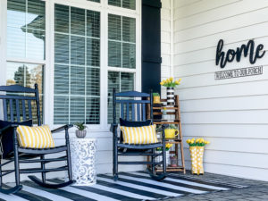 rocking chairs with yellow decor on modern spring front porch