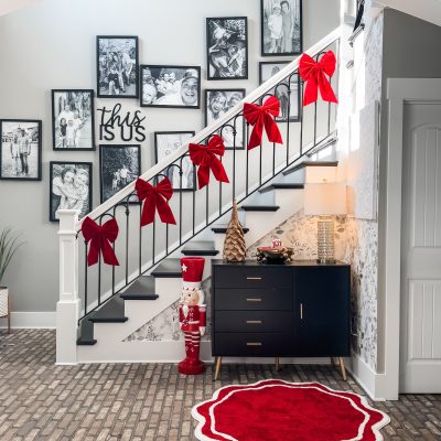 decorating the stairwell in the entryway with red velvet bows